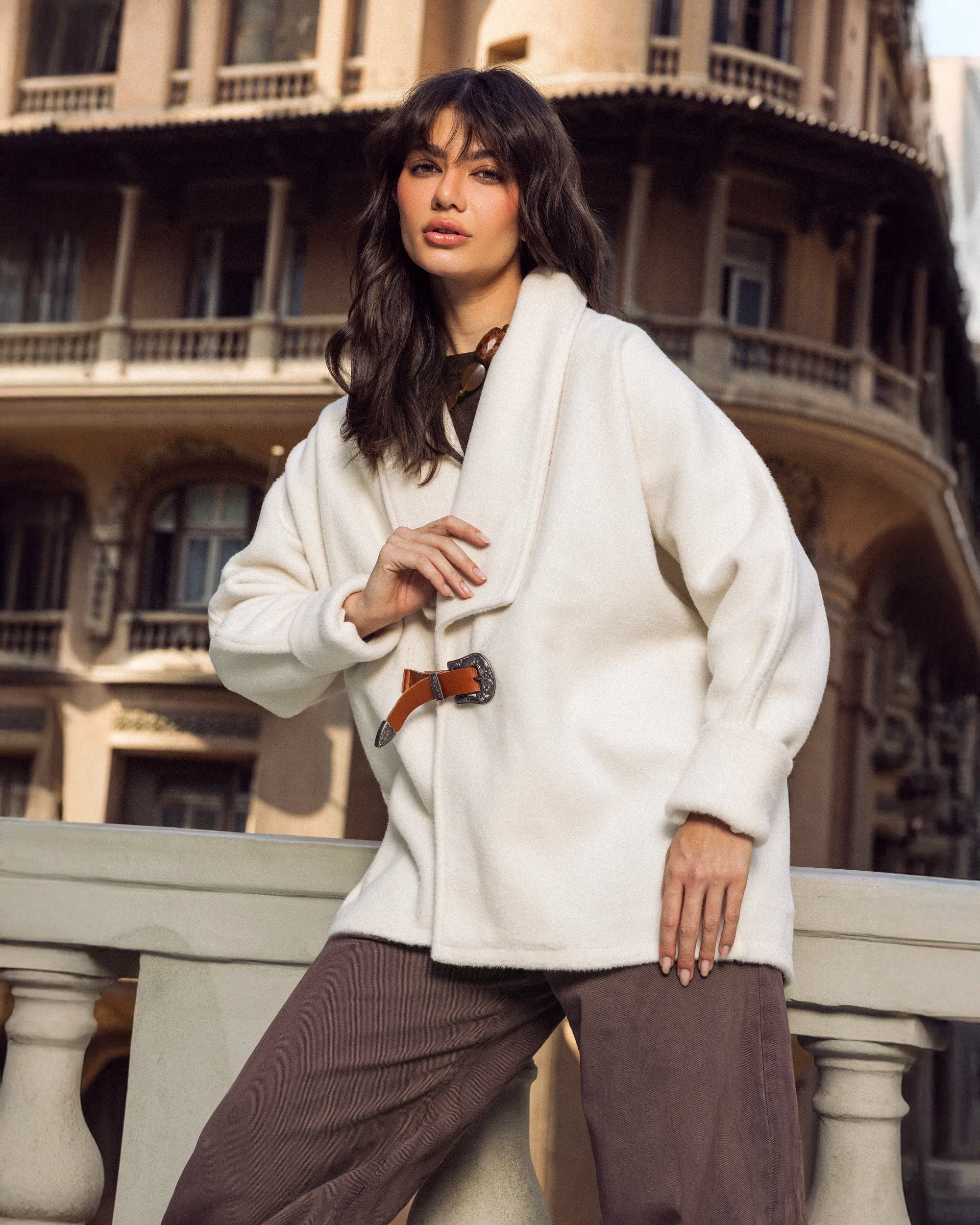 “Side view of the white Belted Jacket showing the soft wool drape and slim belt definition.”