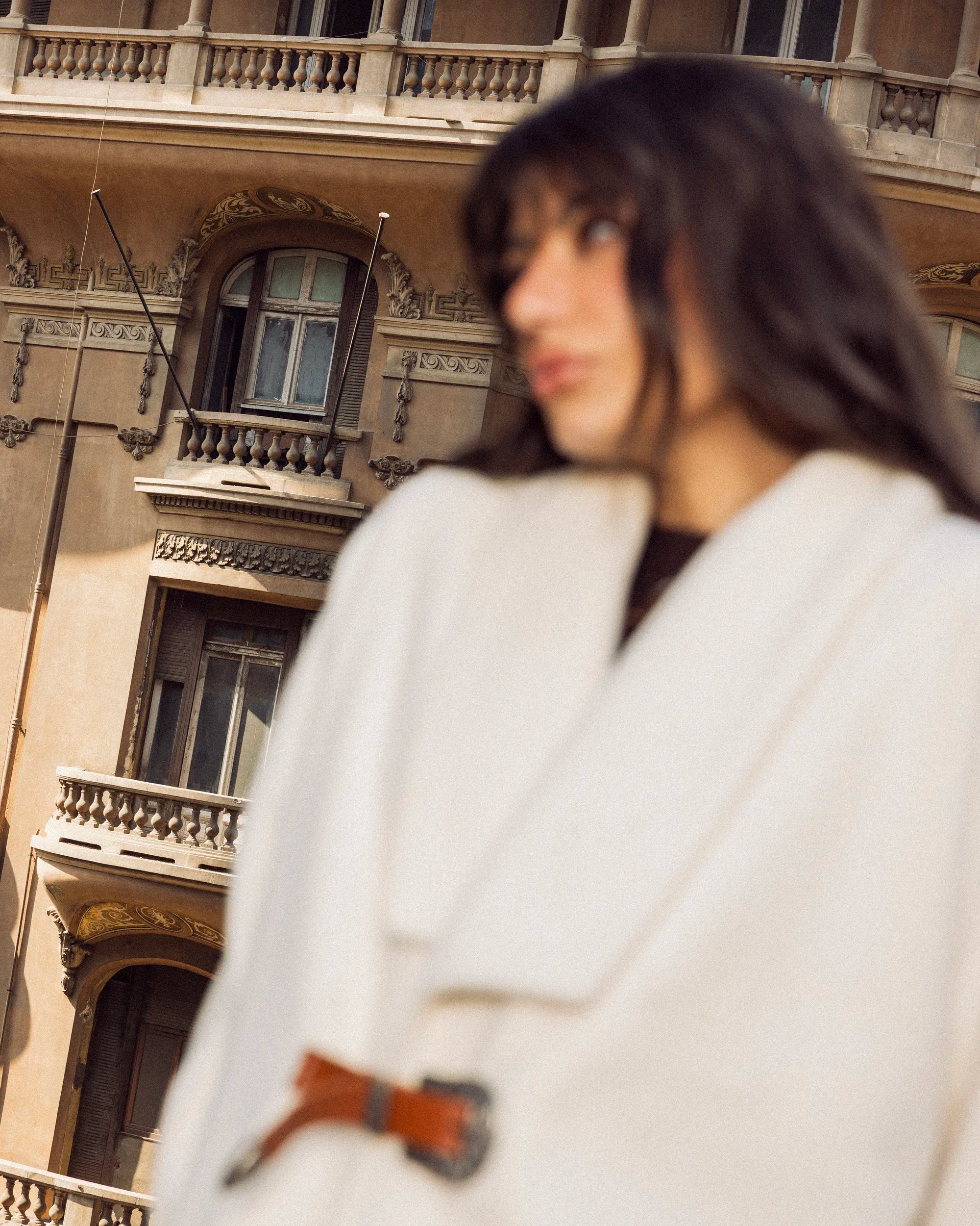 “Close-up upper-body shot of the white Belted Jacket showing wool texture and belt detail.”