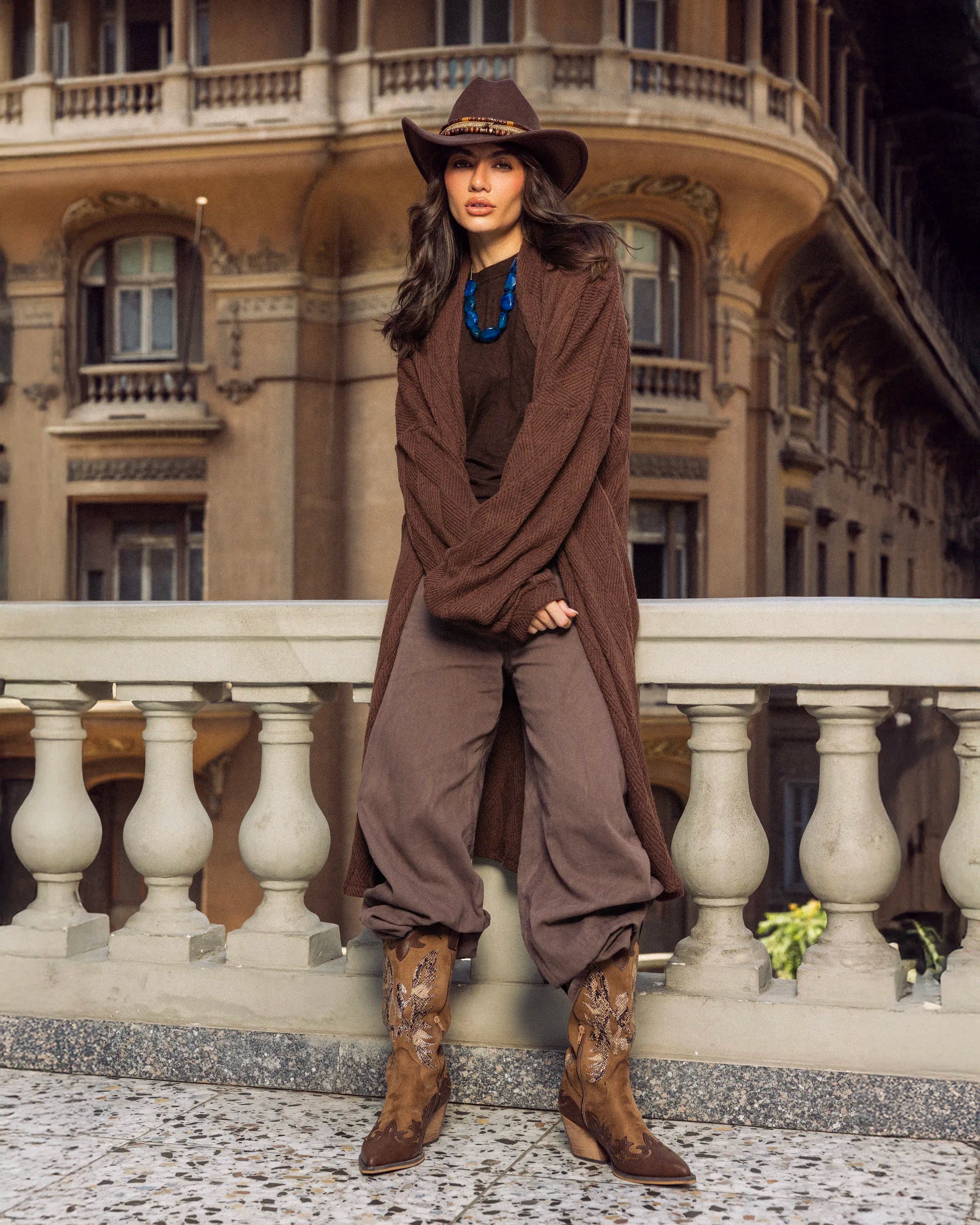 “Front full-body view of the brown Wander Coat showing its long flowing knit silhouette.”