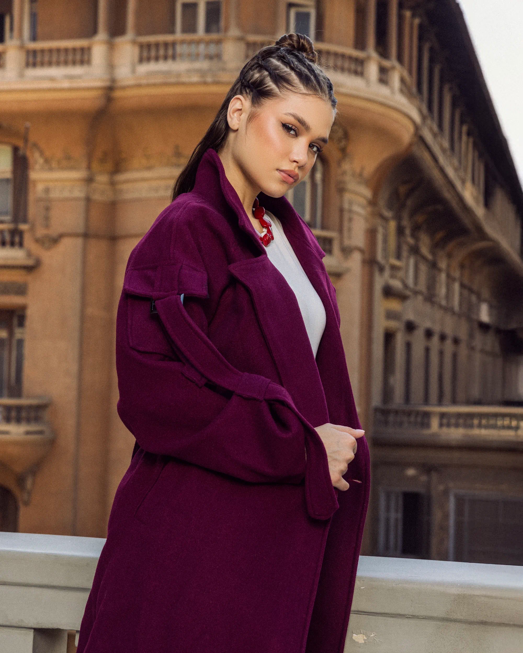 “Side-angle view of the burgundy Bound Coat showing its tailored wool fit and subtle belted waist.”