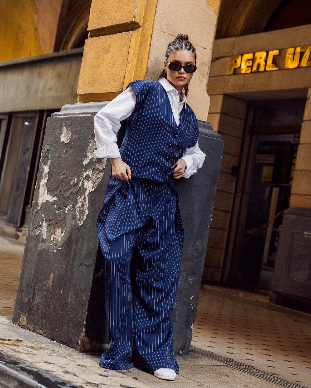 Person wearing a blue pinstripe suit standing in an urban setting