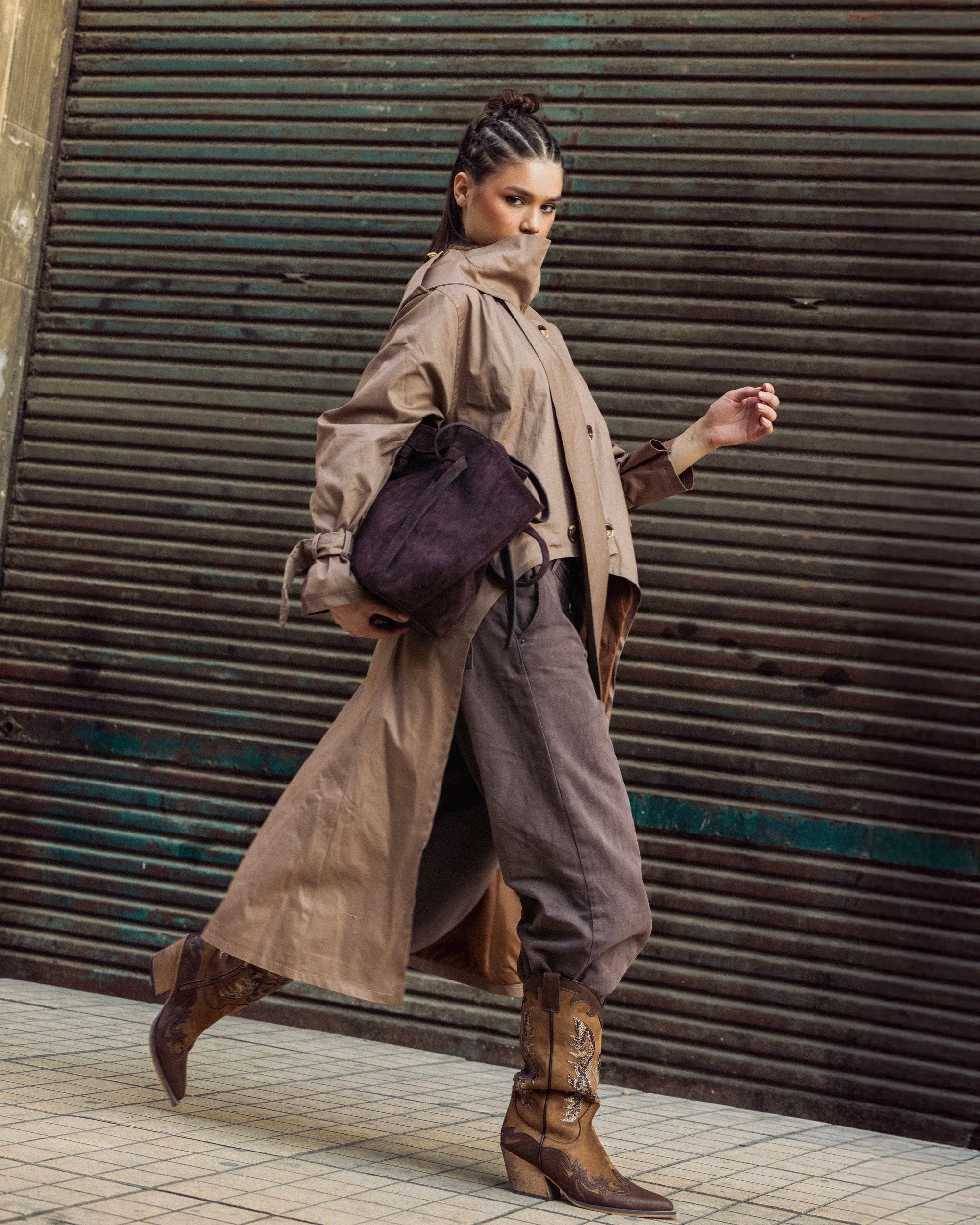 “Walking pose of the black A-Line Coat highlighting its clean structured design and subtle A-line silhouette.”