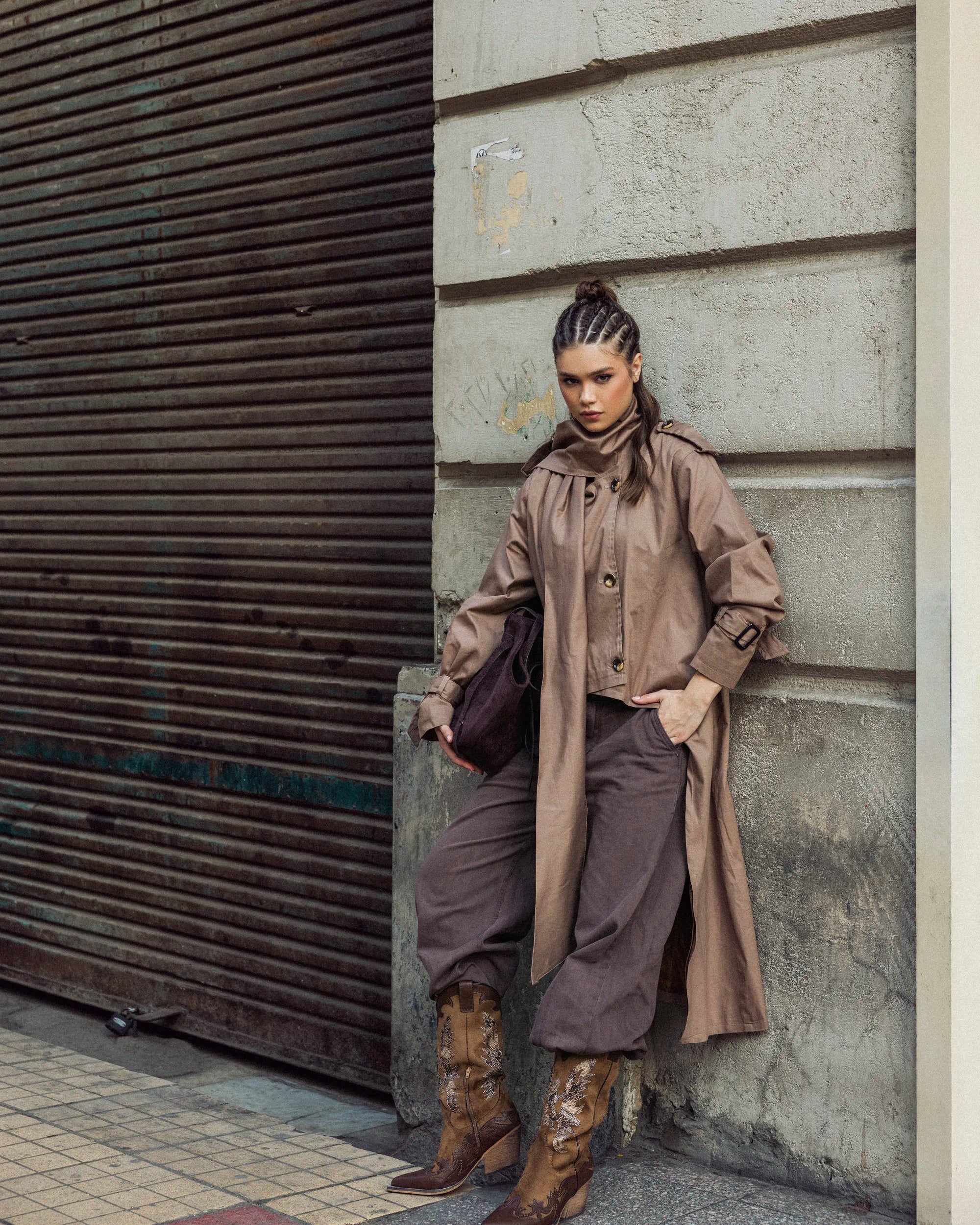 “Relaxed pose wearing the beige A-Line Coat, showing the structured gabardine body and lightweight drape.”