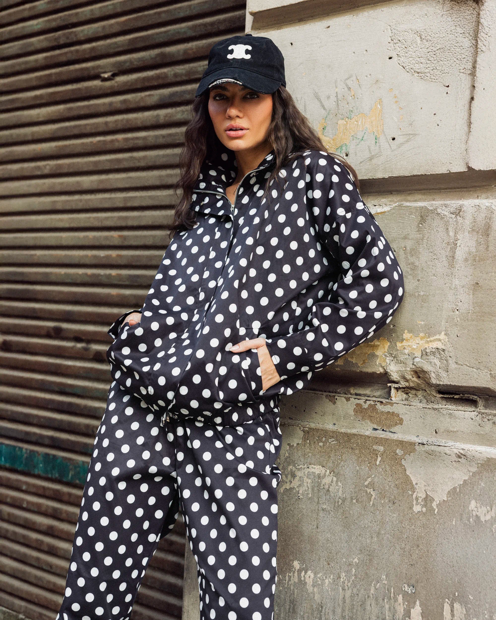 “Side-front sitting pose of the black Polka Set highlighting its relaxed silhouette and polka-dot pattern.”