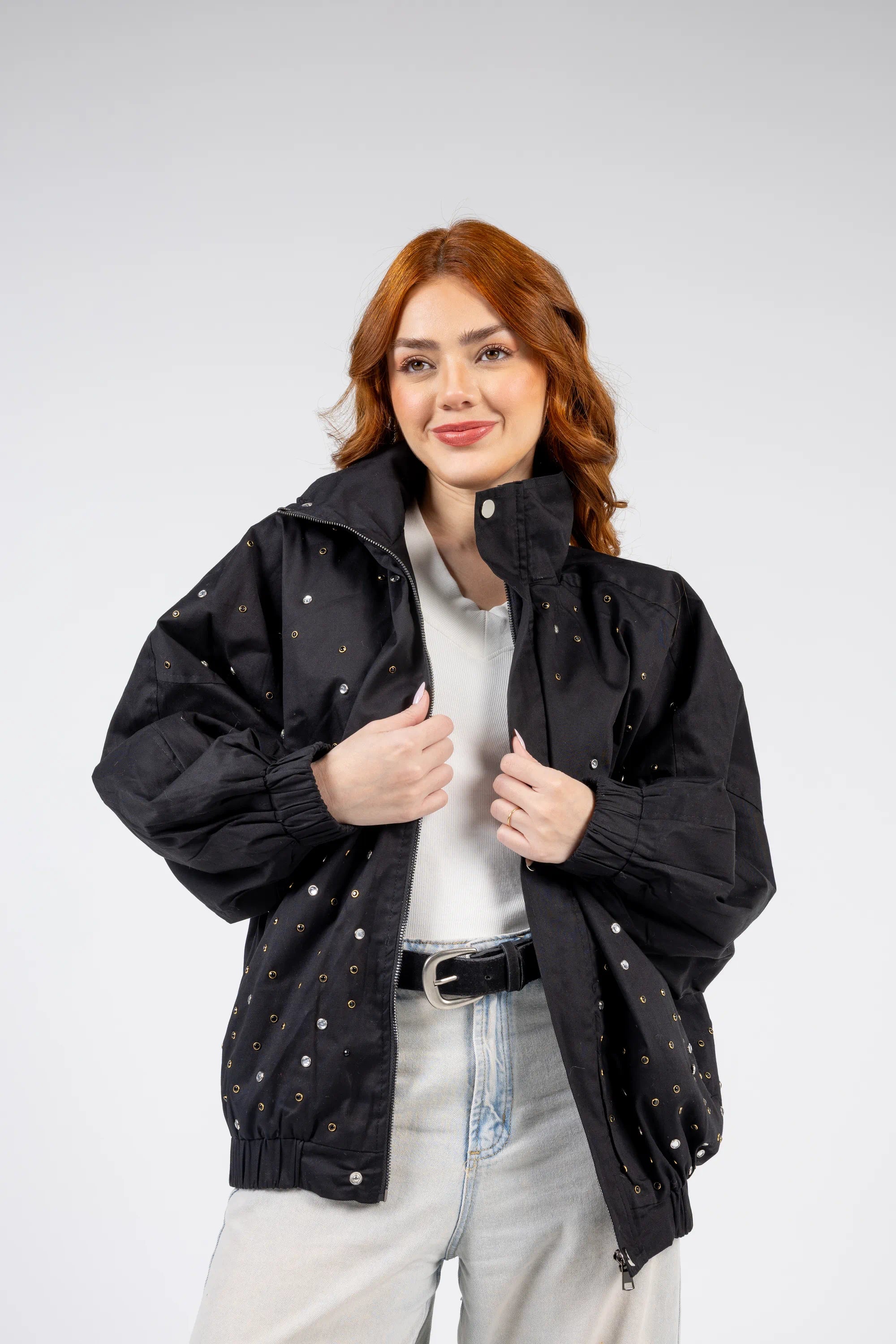 Woman wearing a black jacket with white polka dots on a light gray background