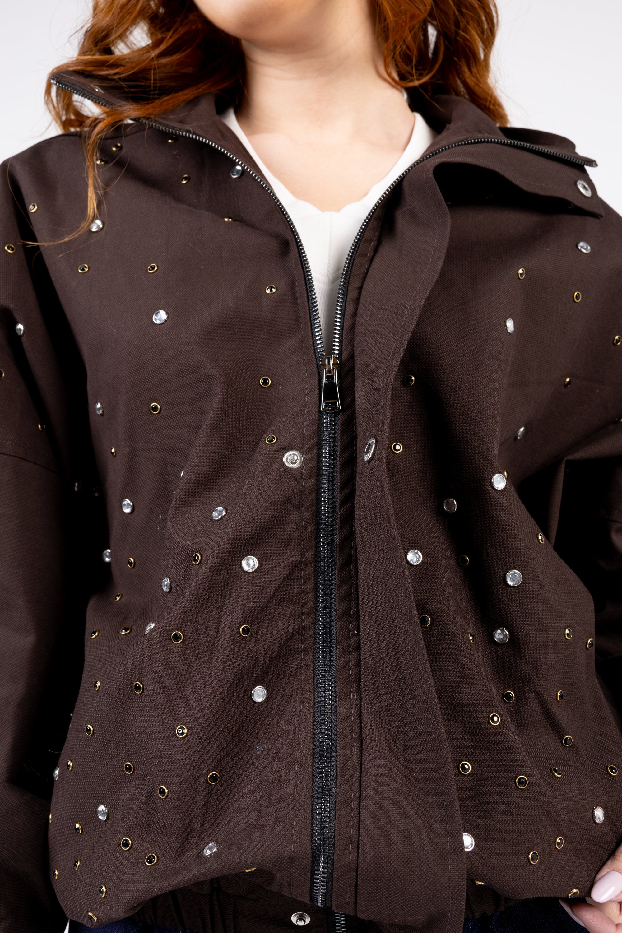 Brown jacket with decorative studs on a plain background