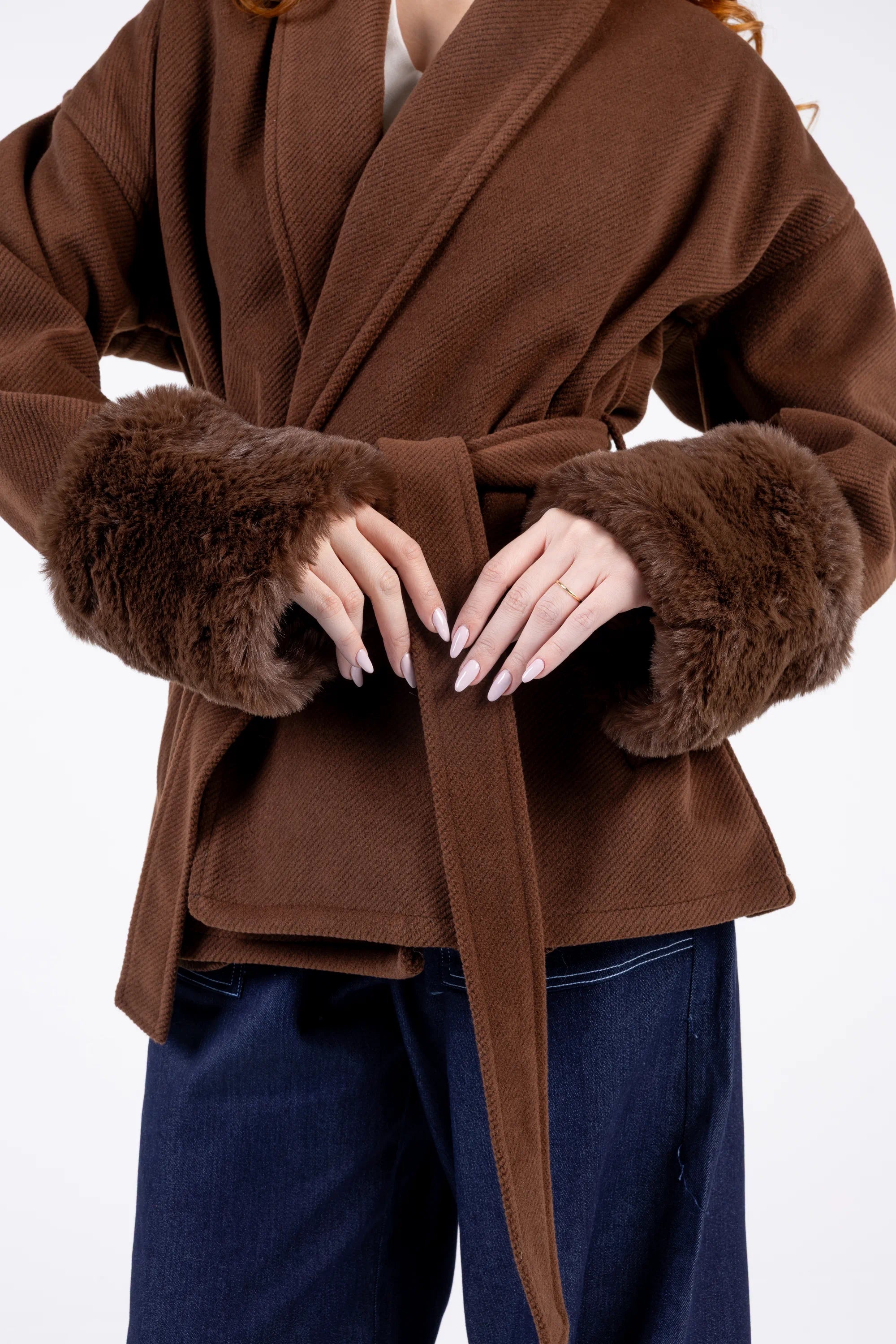 Brown coat with fur cuffs and a belt, worn by a person on a white background
