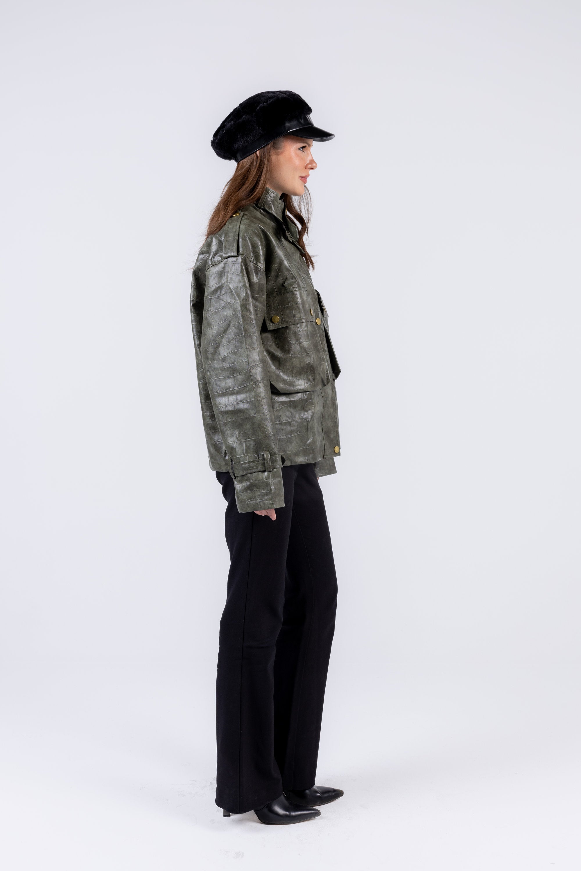 Person wearing a green jacket and black hat on a white background