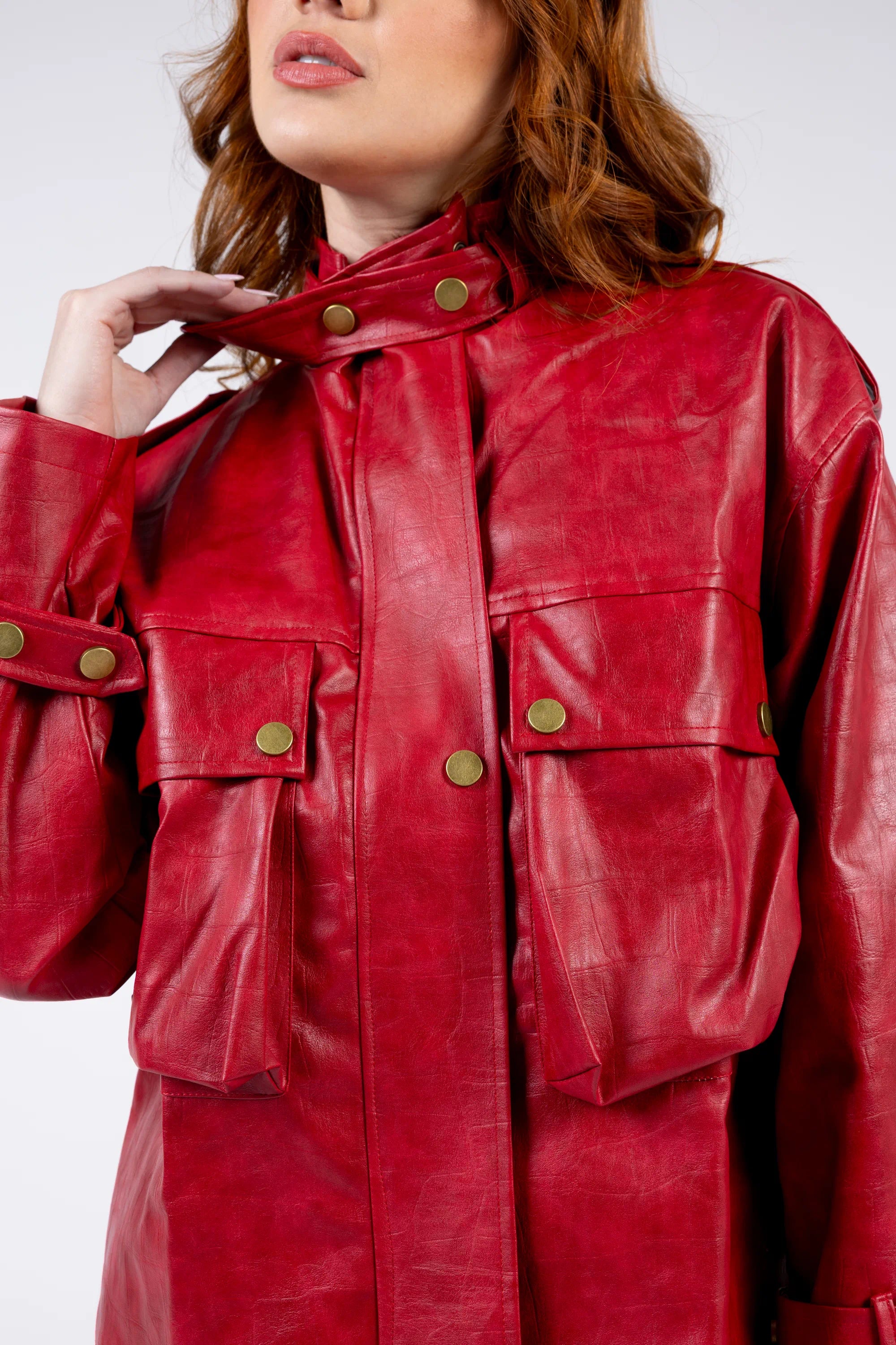 Red leather jacket with gold buttons worn by a person on a white background