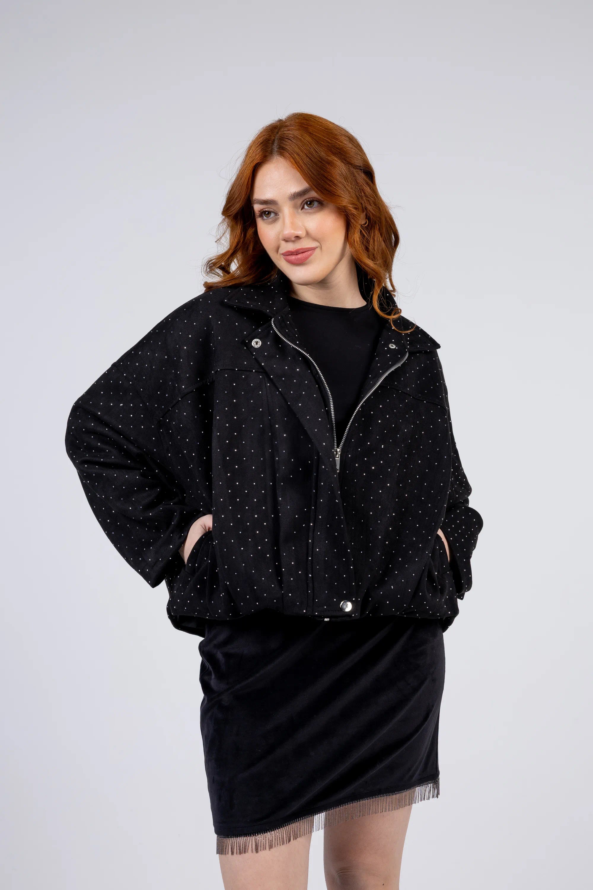 Woman wearing a black jacket with white polka dots on a white background
