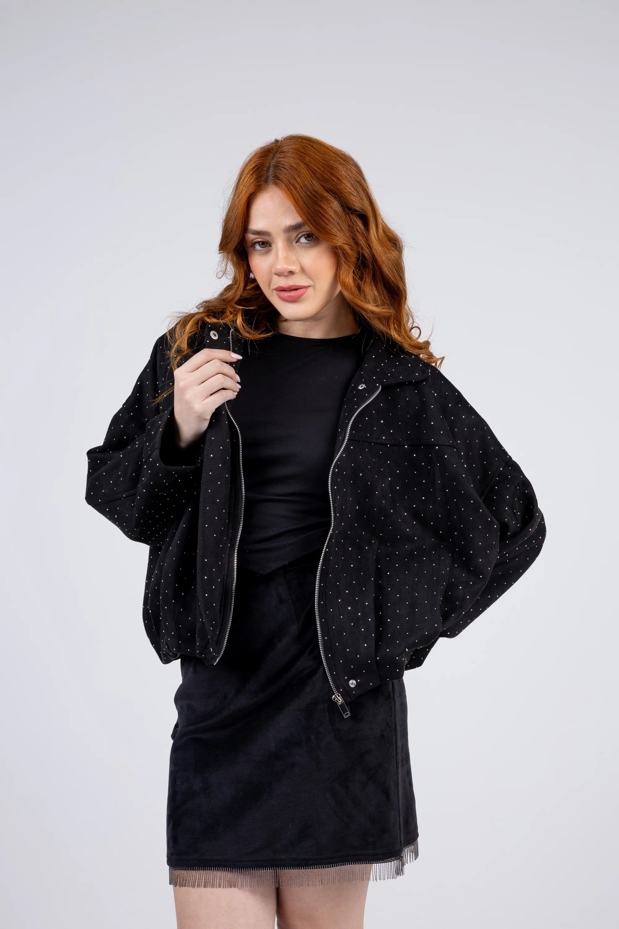 Woman wearing a black jacket over a black dress on a white background