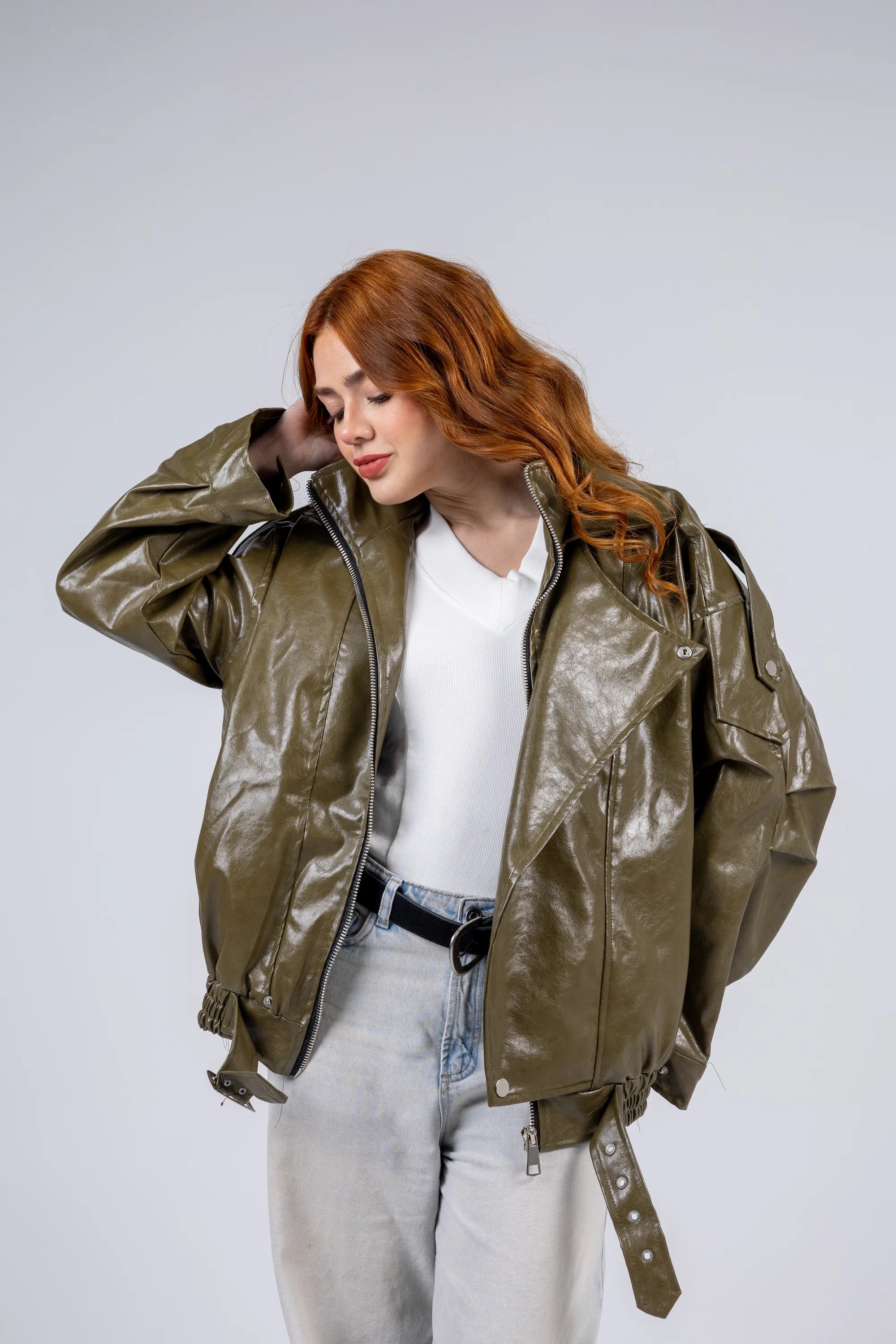 Woman wearing a shiny green jacket on a white background