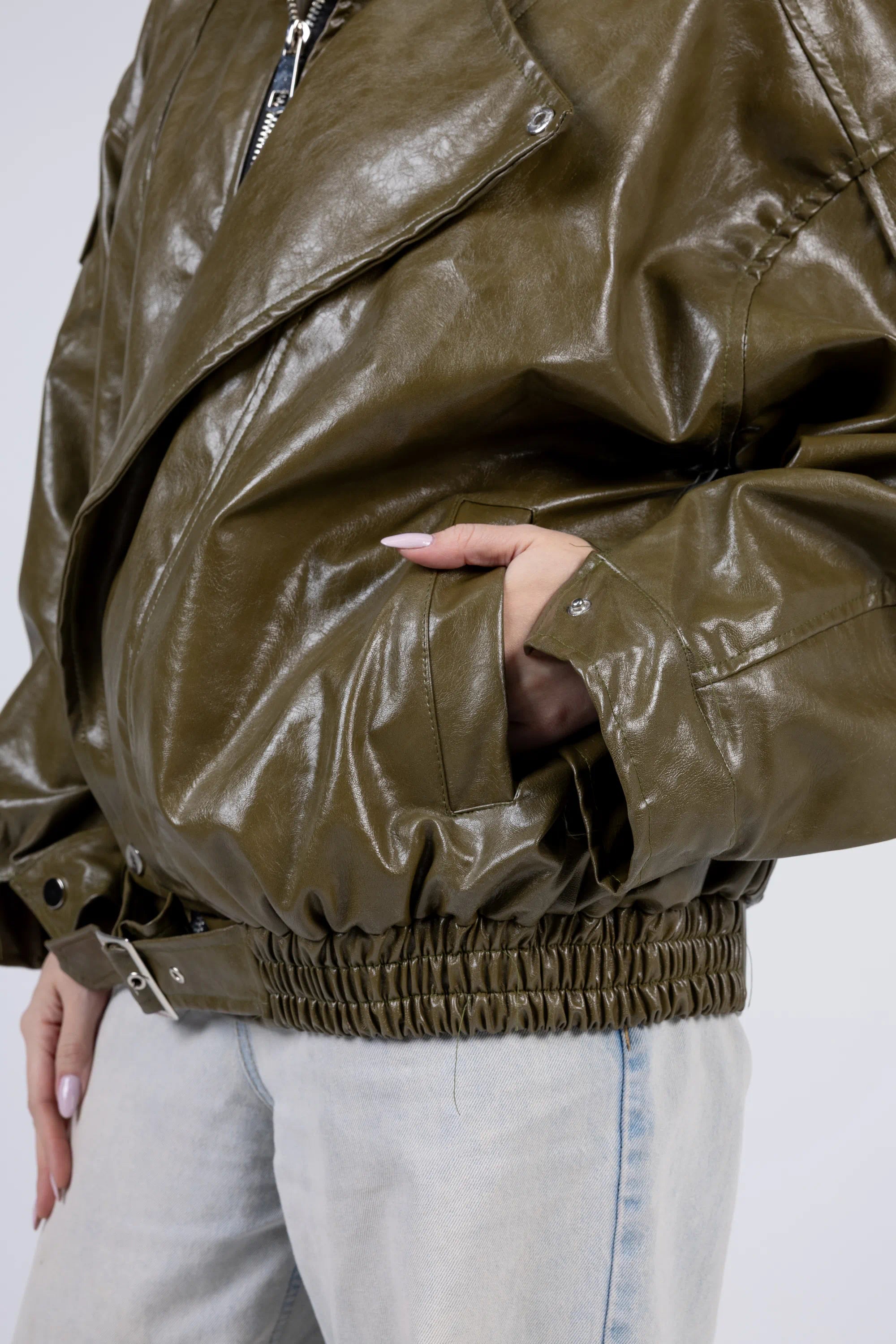 Close-up of a person wearing a shiny brown jacket with a neutral background