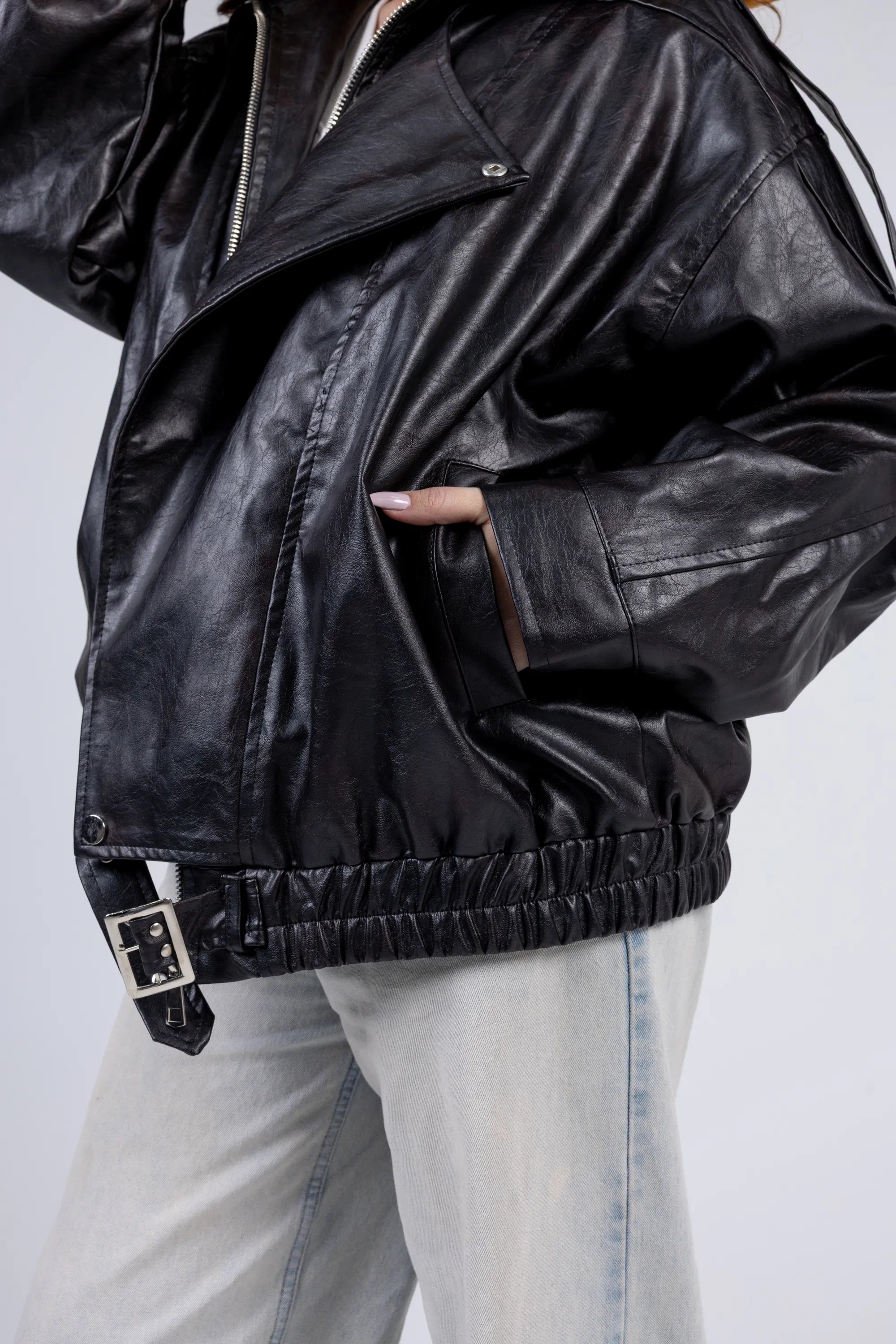 Person wearing a black leather jacket on a light gray background