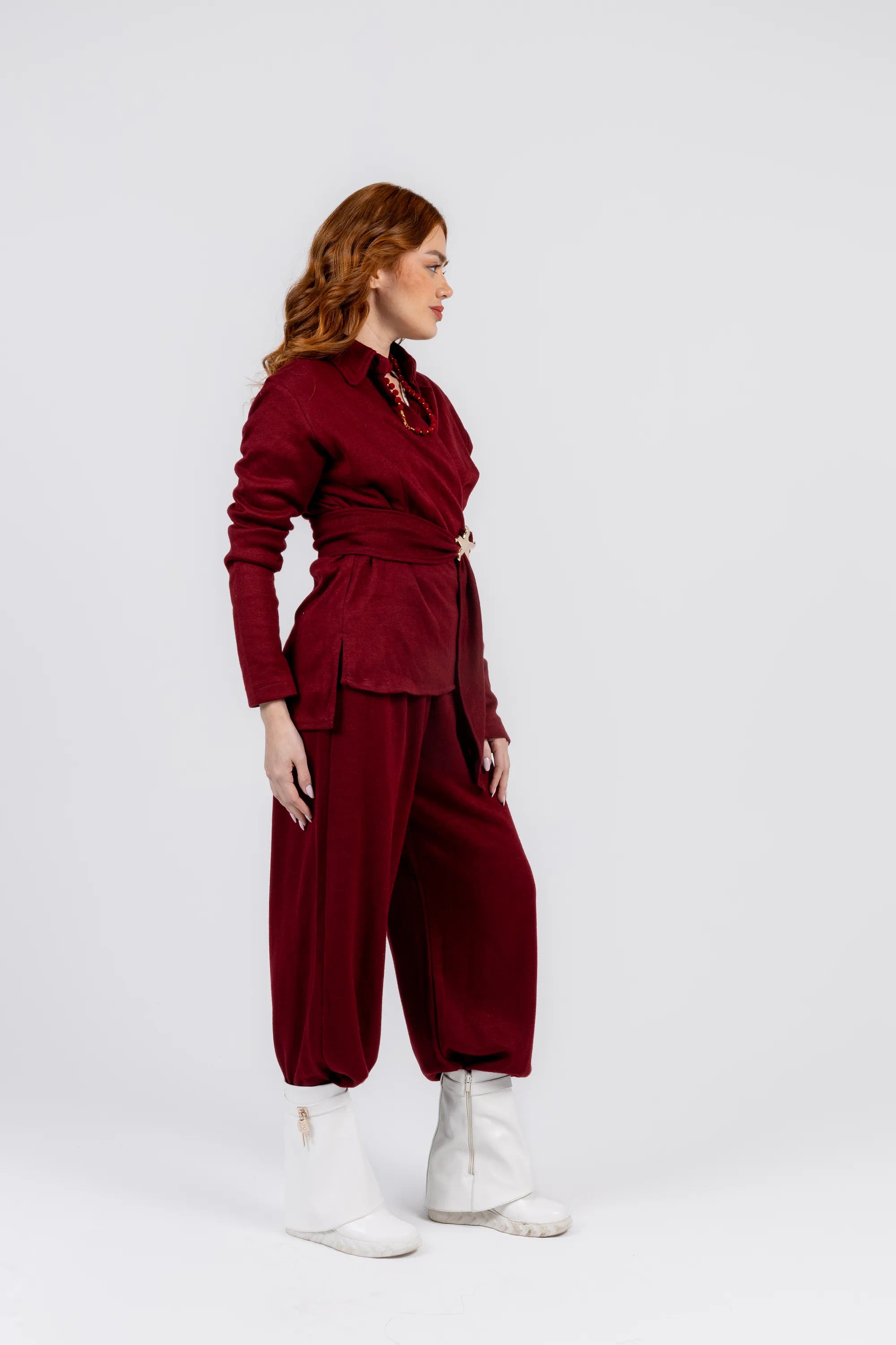 Woman wearing a burgundy outfit with a white background