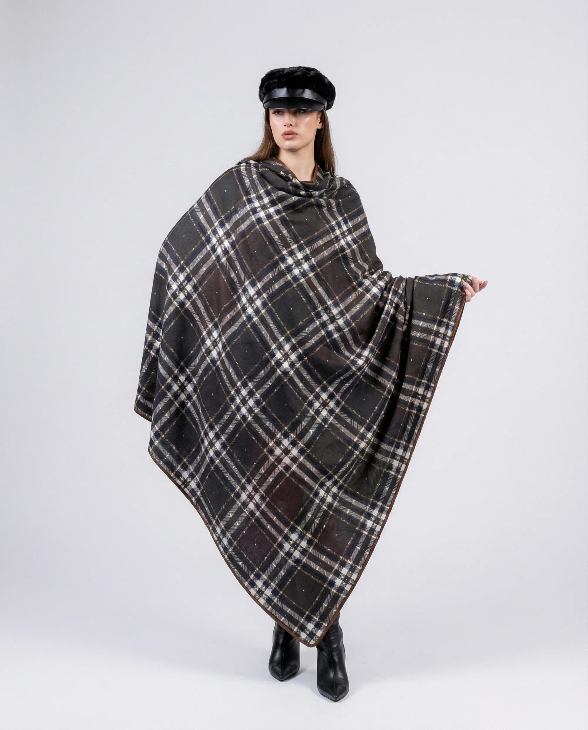 Person wearing a plaid poncho on a white background