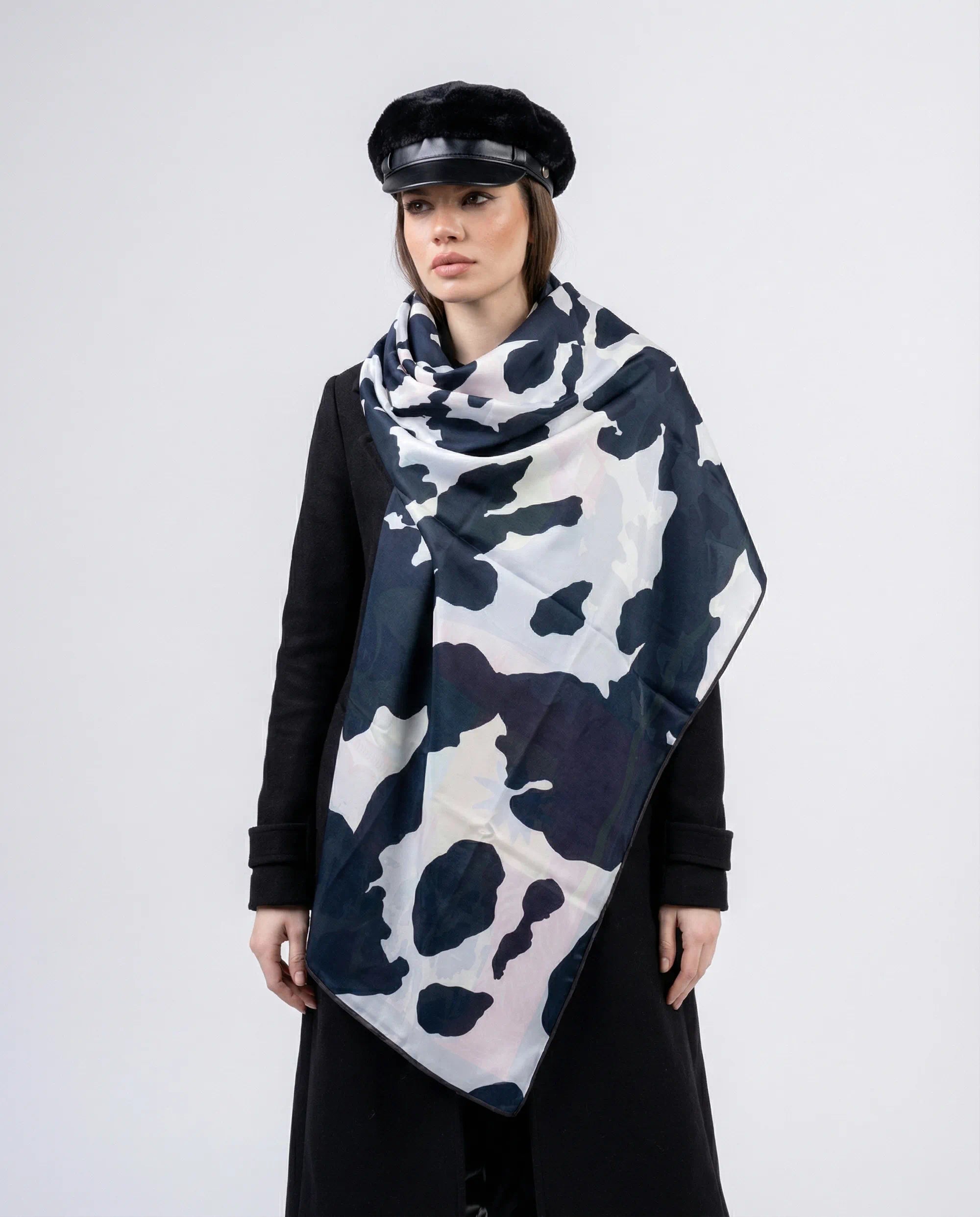 Woman wearing a black and white patterned scarf on a white background