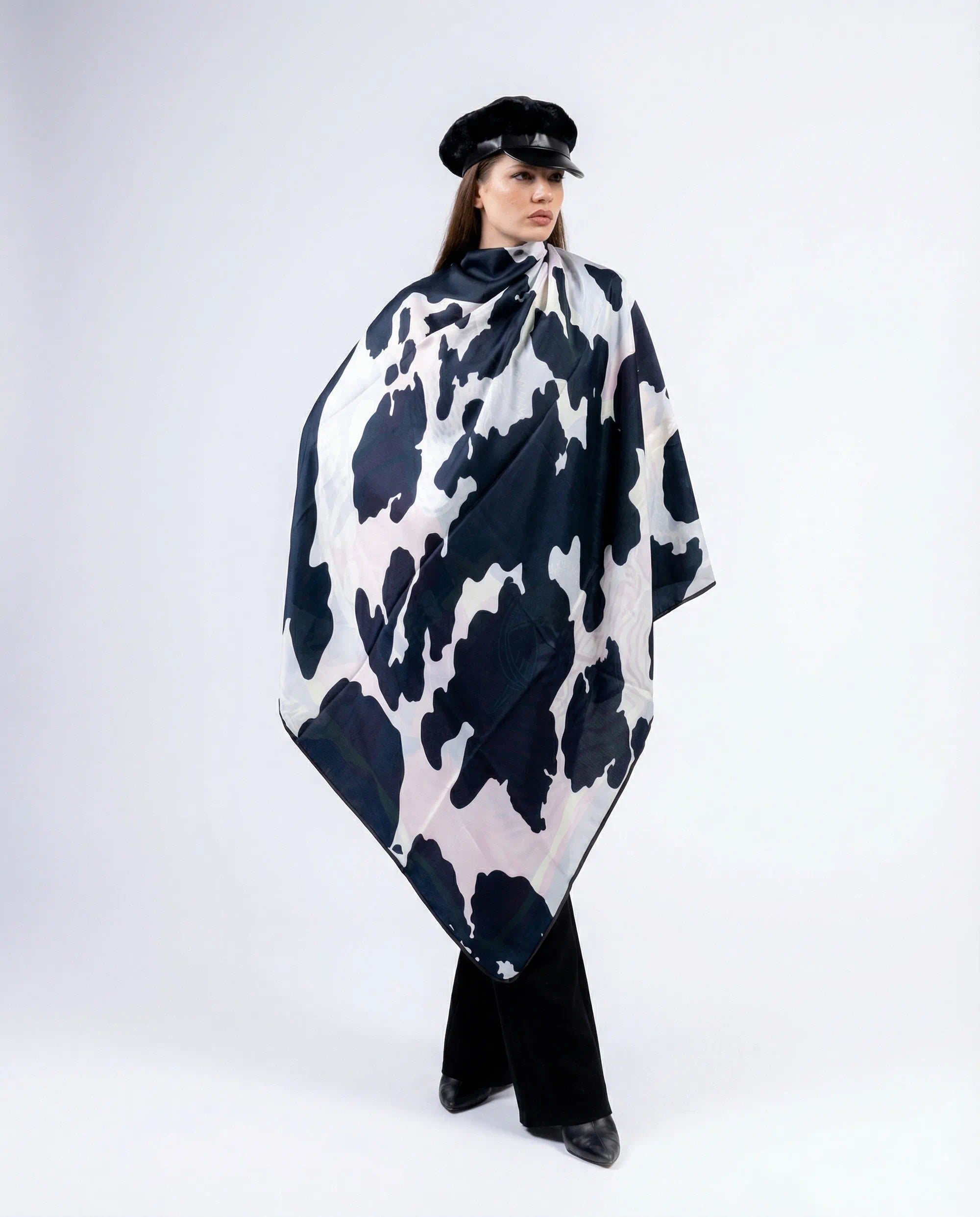 Person wearing a black and white patterned scarf on a white background