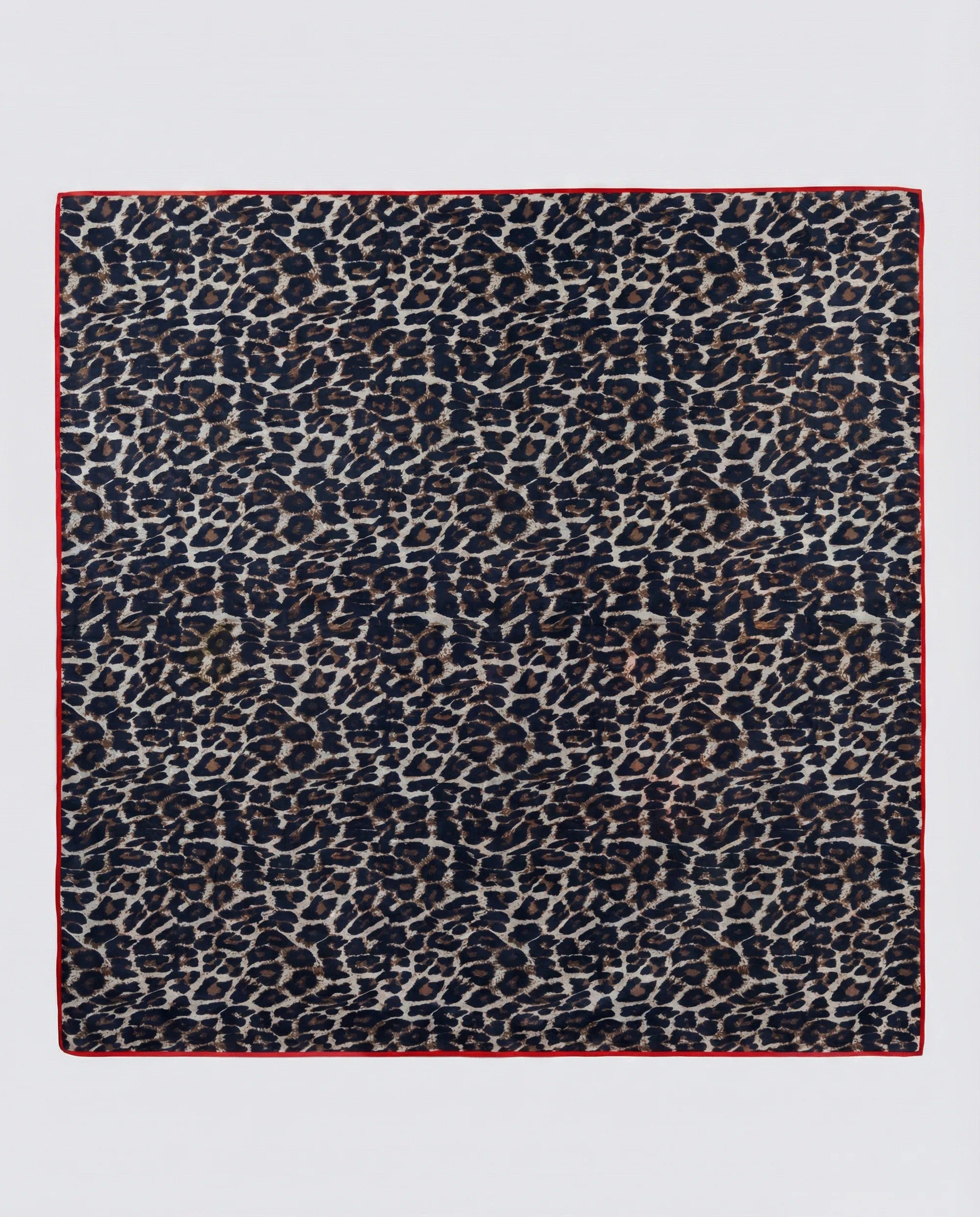 Leopard print pattern on a square fabric piece with a red border.