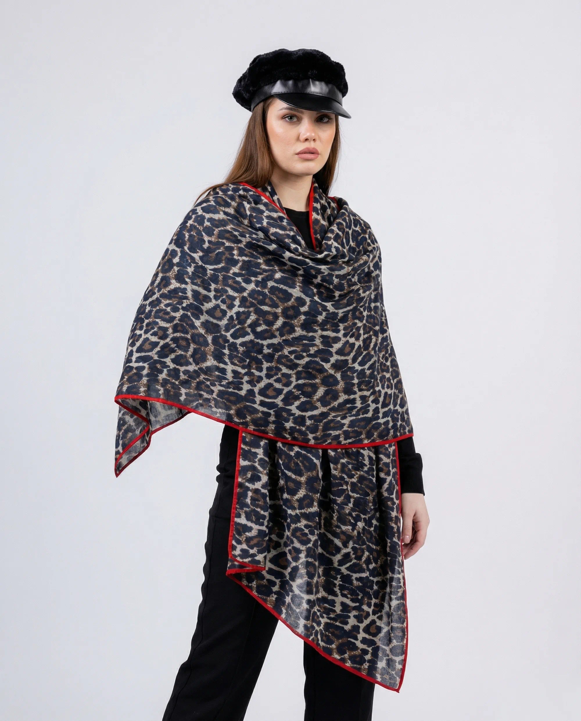 Woman wearing a leopard print scarf with red trim on a white background