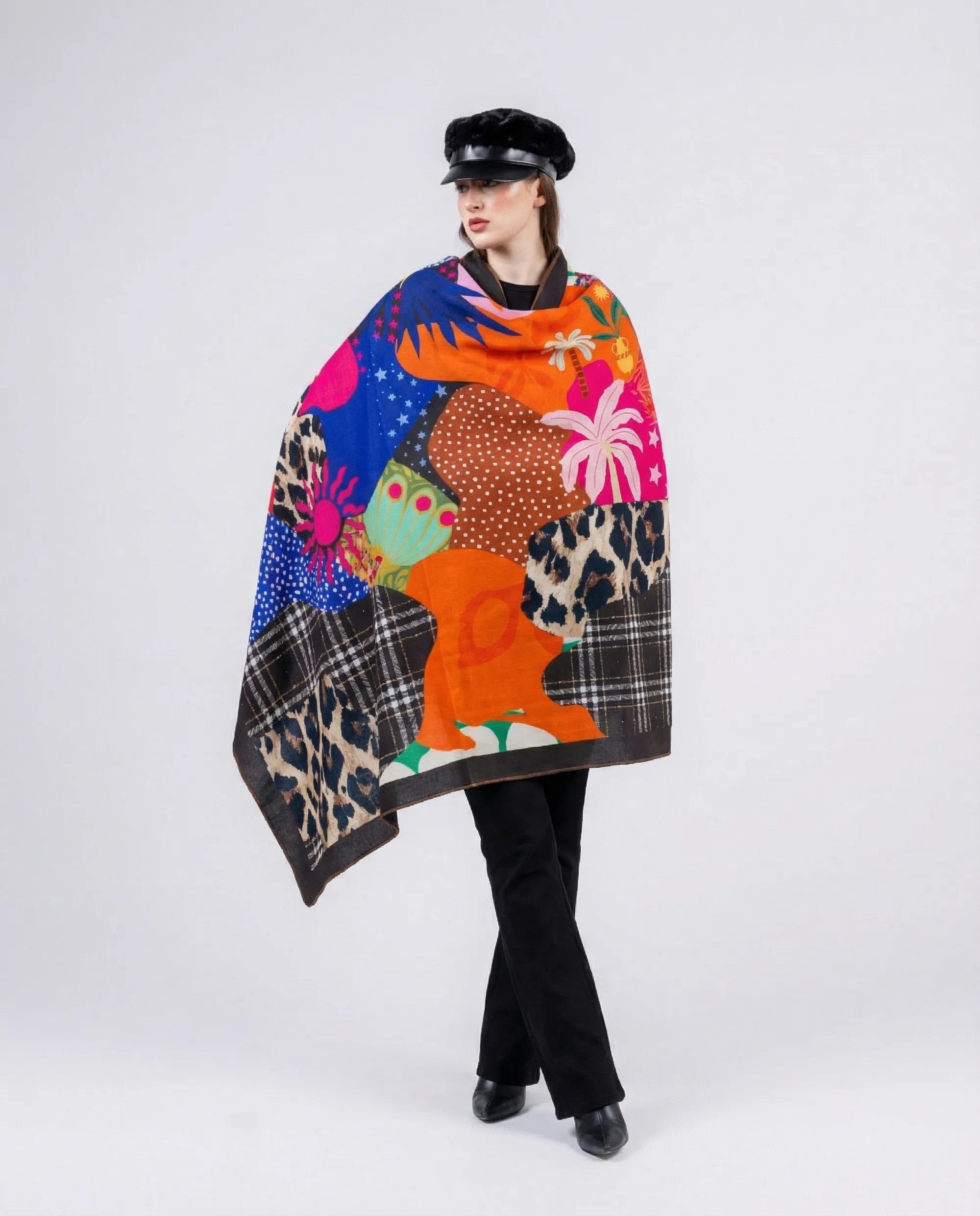 Person wearing a colorful patterned poncho on a white background